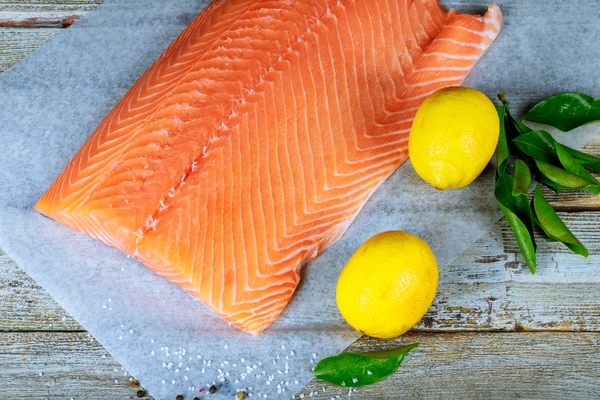 Fisch Rohes Lachsfilet Pfeffer Salz Dill Zitrone auf Holztisch