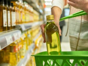 person shipping an olive oil bottle