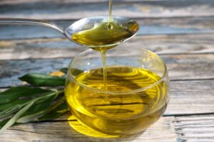 Olive Oil Pouring In A Glass Bowl